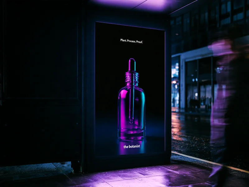 The Botanist — a backlit street poster at night showing the serum, with the headline Plant. Process. Proof.